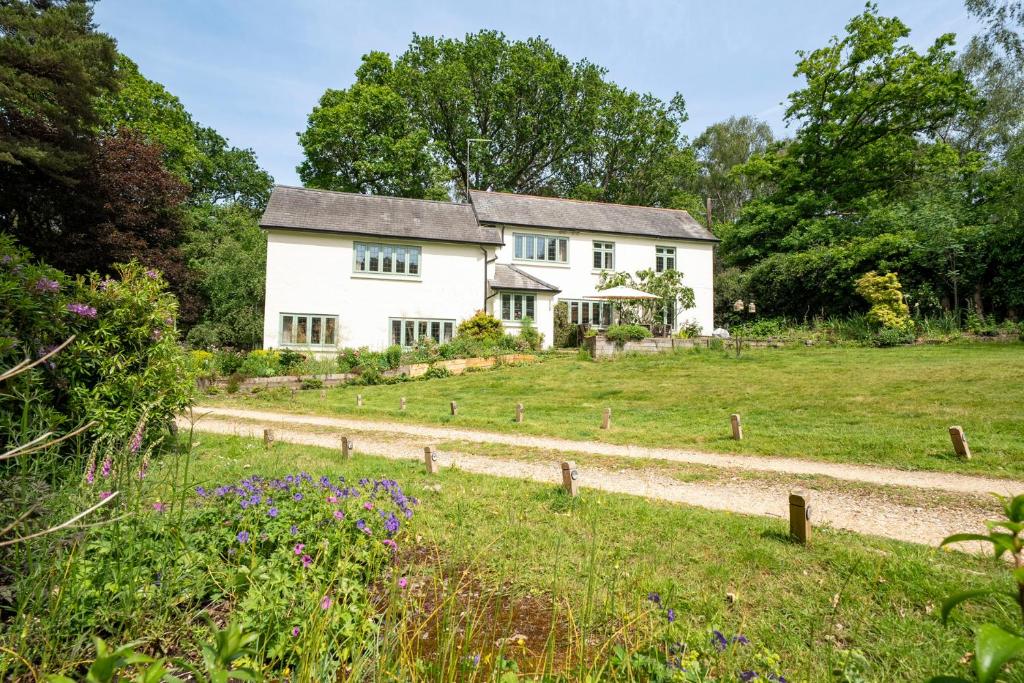 a white house in a field with a gravel road at Primrose Spinney in Ringwood