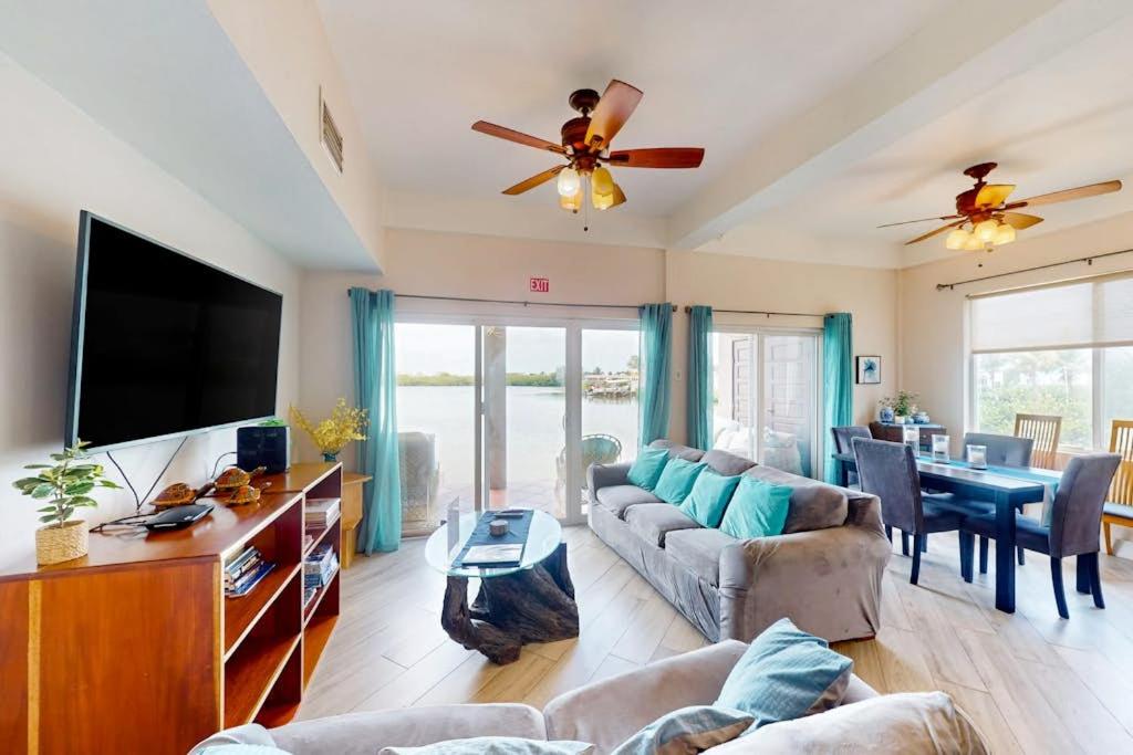 a living room with a couch and a flat screen tv at Suite H103 @ Mara Laguna in San Pedro