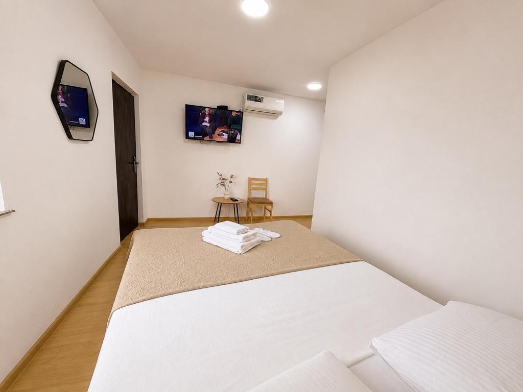 a bedroom with a bed and a tv on the wall at MaVi House in Kutaisi