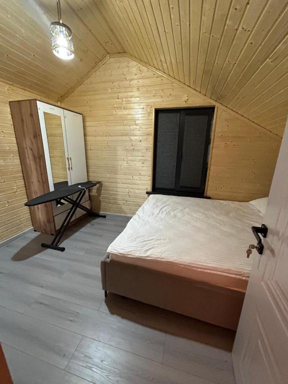 a bedroom with a bed and a table in it at MMED SWEET HOMe in Bosteri