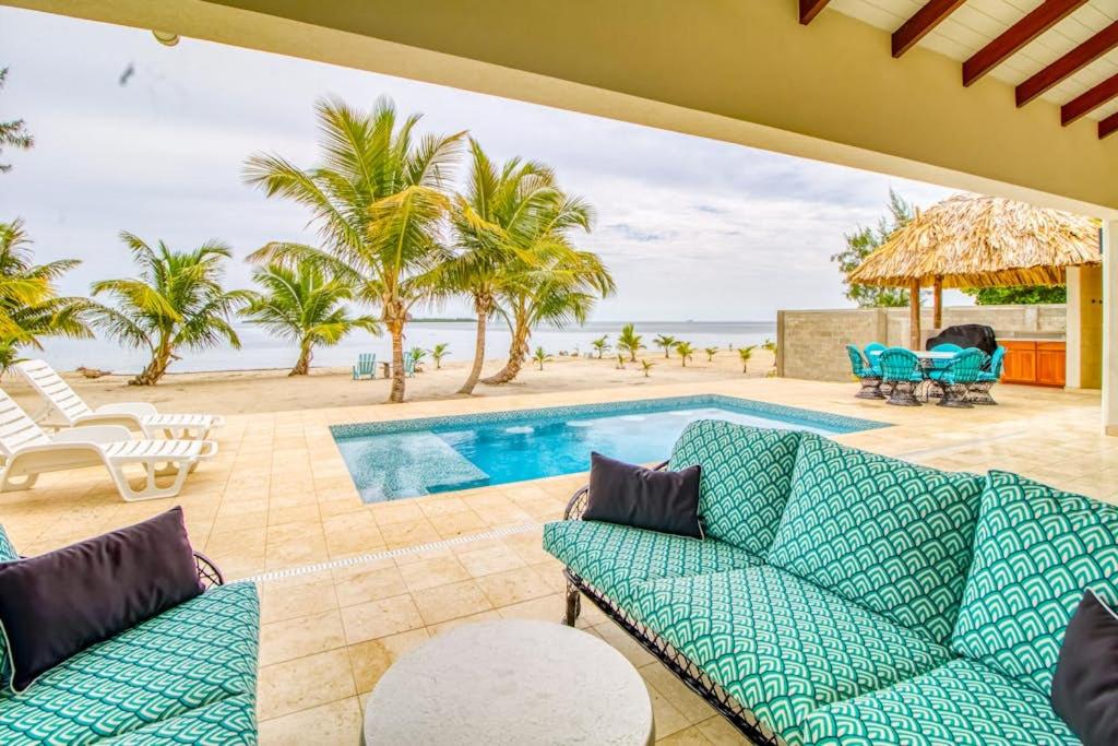 a patio with a swimming pool and palm trees at Tres Palmas Beach House in Maya Beach