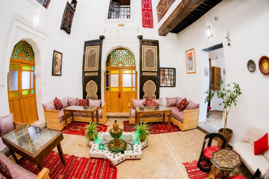 a living room with couches and a table at Riad Al Fanouss in Fez