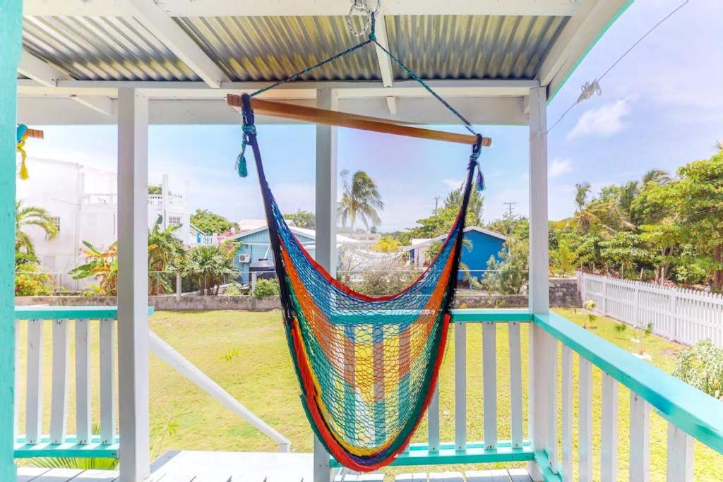 a hammock on the porch of a house at DV #1 at DV Cabanas - Gold Standard Certified in Caye Caulker