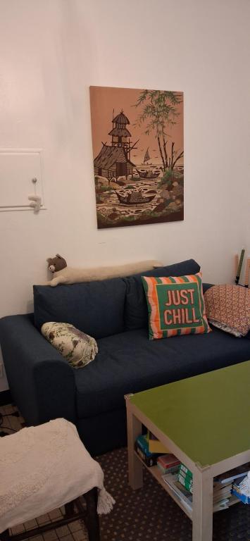 a living room with a blue couch and a green table at Ma maison du port in Guipry-Messac
