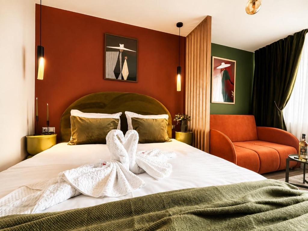 a bedroom with a bed with two towels on it at Zara Home Cozy Studio in Petroşani
