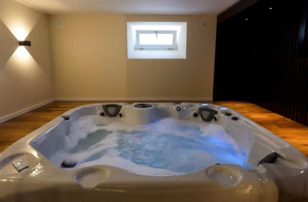 a jacuzzi tub in a room with a window at Le Domaine Endila in Munster