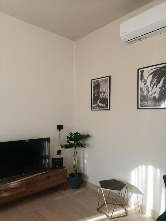 a living room with a flat screen tv on a white wall at Casa Autentica 1933 in Kos