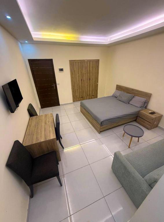 a bedroom with a bed and a couch and a table at Palm Dorms in Beirut
