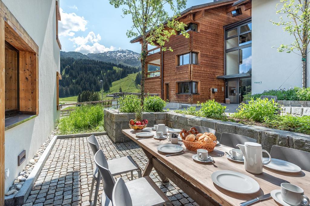 ein Holztisch und Stühle auf einer Terrasse in der Unterkunft Turrabuel in Parpan