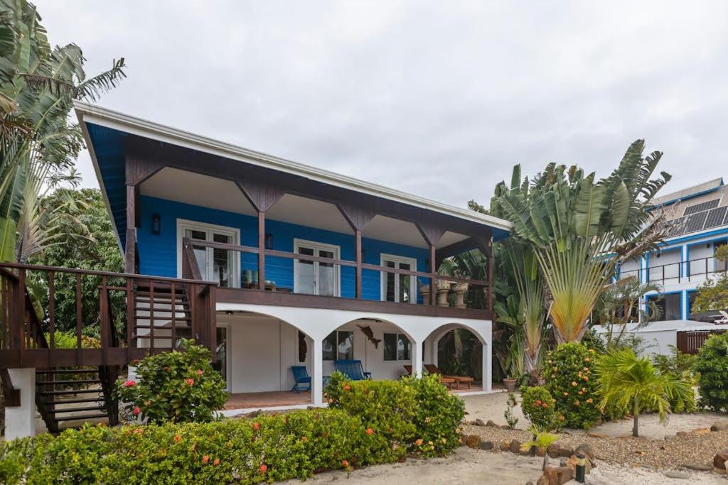 a blue and white house with palm trees at Casa Edie in Placencia