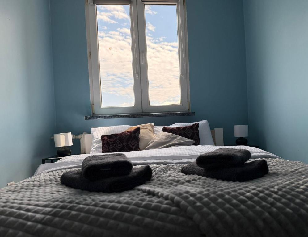 a bedroom with a bed with two towels on it at Apartament Sudeckie Kamyki in Głuszyca