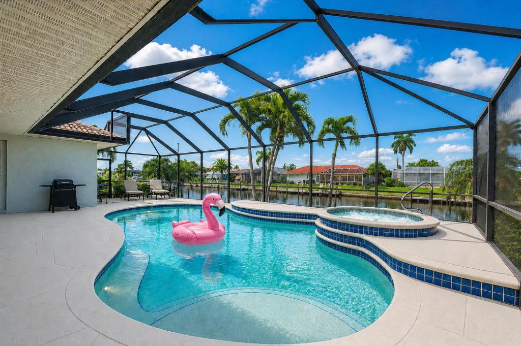 a swimming pool with a pink swan in the water at 830 Coronado in Punta Gorda