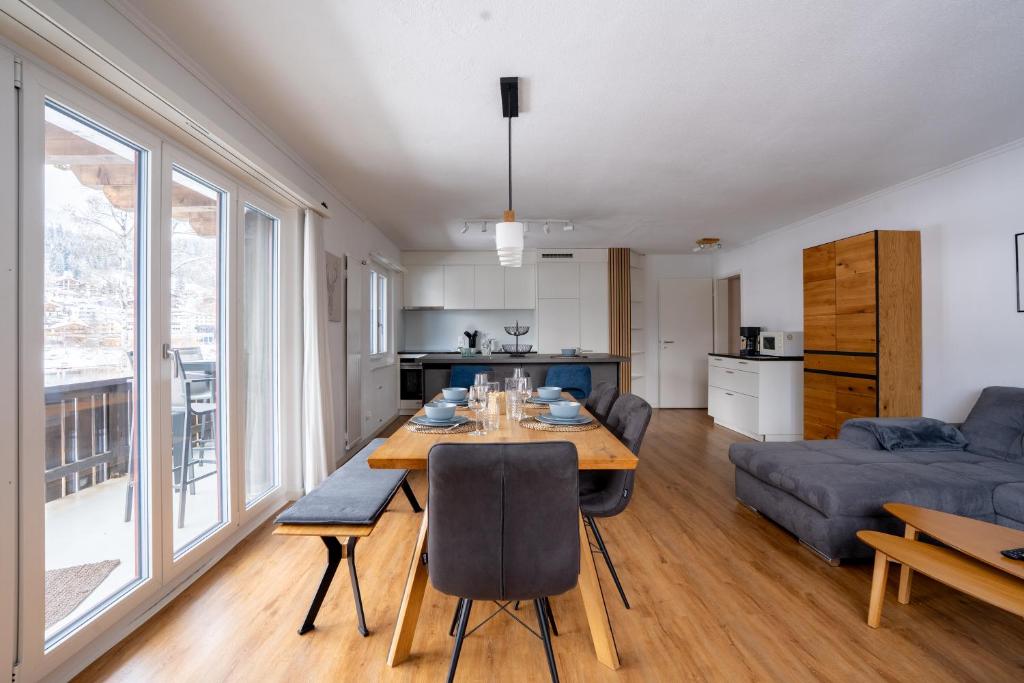 a kitchen and living room with a table and a couch at La Riva mit Berg- und Seeblick in Laax