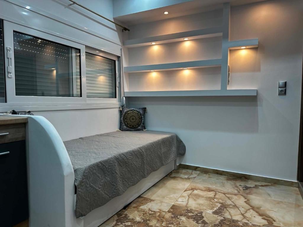 a small bedroom with a bed and a window at Bazakos Luxury Kampi Beach Studio 2 in Fournoi