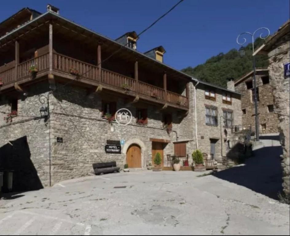 a large stone building with a balcony on top of it at Casa Peiró in Coll