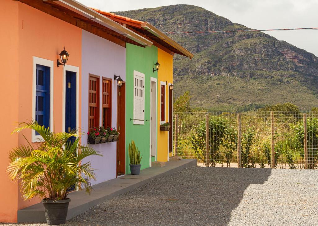 a colorful house with a mountain in the background at Vila Caetité - Mucugê in Mucugê