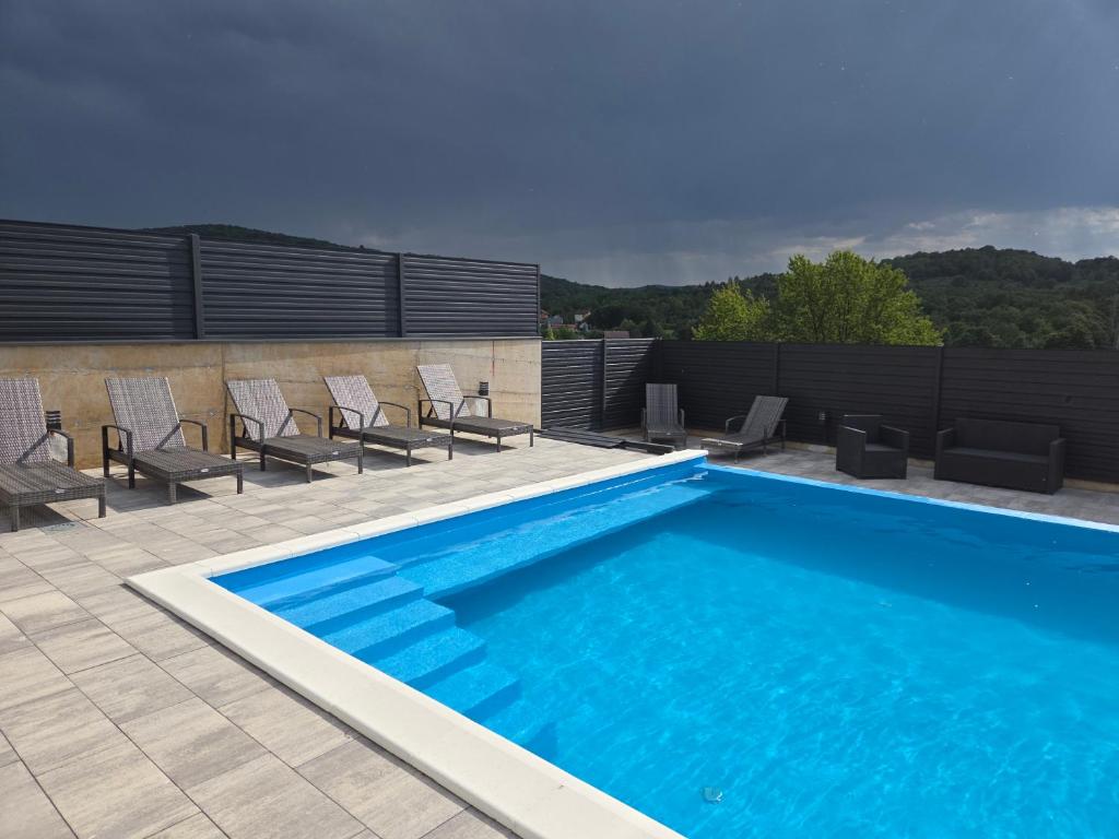 a swimming pool with chairs on a patio at Rooms GRIZZLY in Slunj