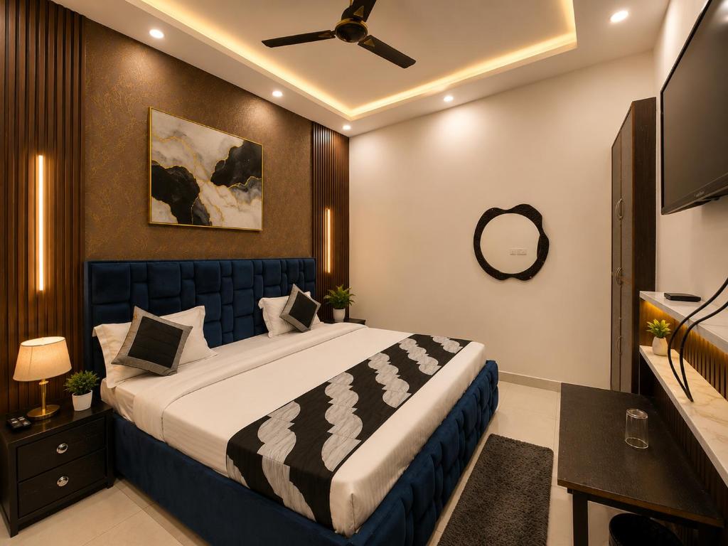 a bedroom with a large bed with a ceiling fan at Hotel Gareen By Du Rooms Near Delhi University Kamlangar in New Delhi