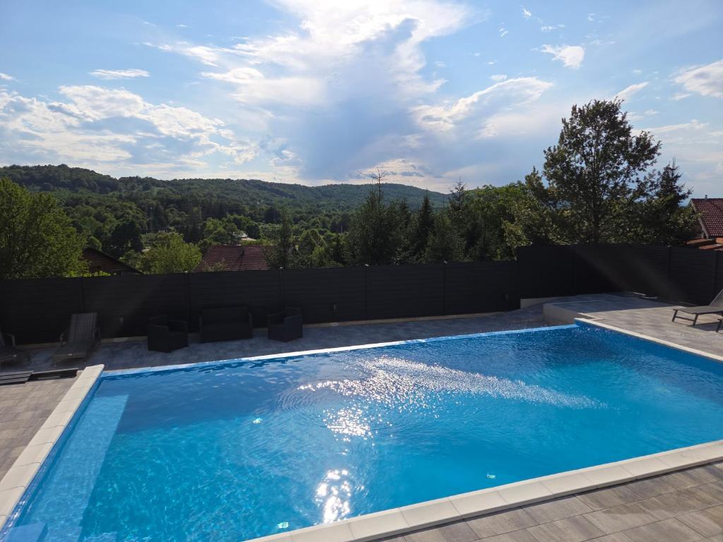 a swimming pool with a view of the mountains at GRIZZLY apartment for the disabled in Slunj