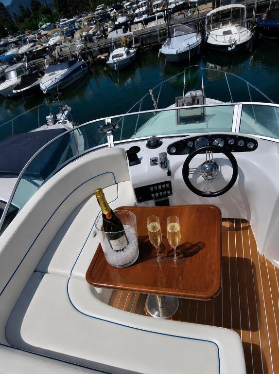 a table with two glasses and a bottle of wine on a boat at bahati blue riviera in Mandelieu-La Napoule