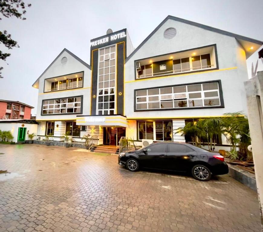 a black car parked in front of a building at Presken Hotel Mojidi, Allen Ikeja in Ikeja