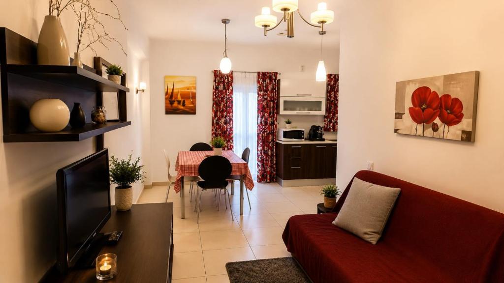a living room with a red couch and a table at Sliema central apartment in Sliema