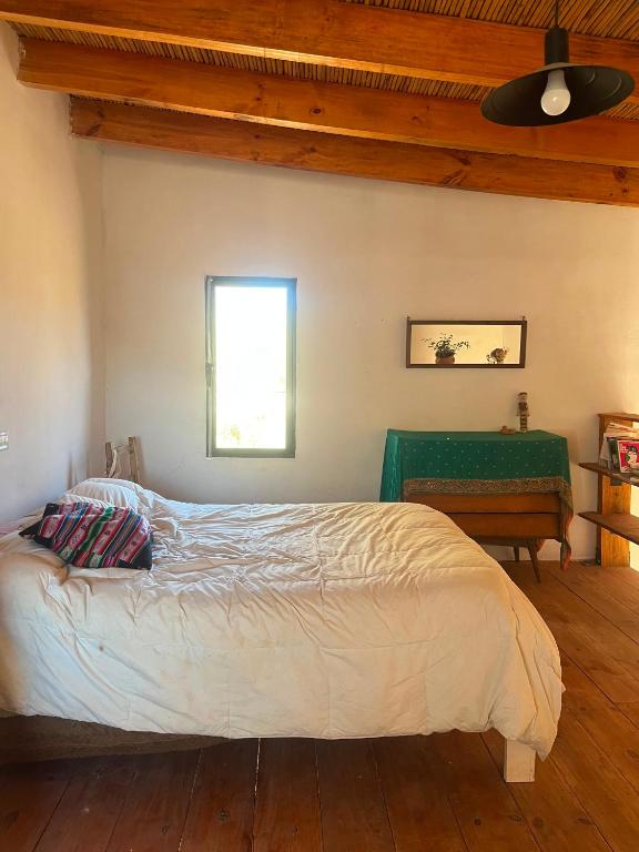 ein Schlafzimmer mit einem großen Bett und einem Tisch in der Unterkunft Maima in Maimará