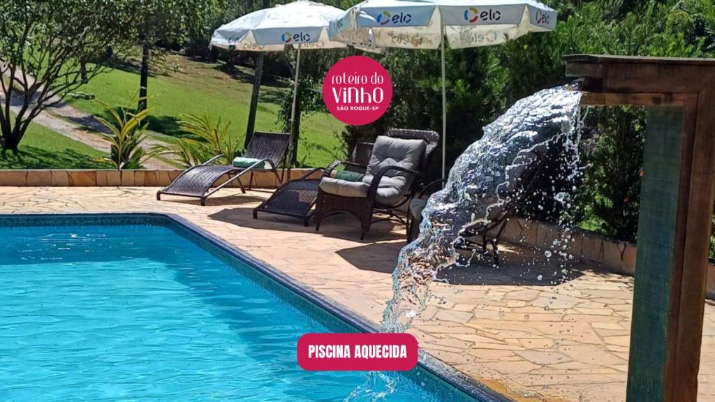 a pool with a water fountain in the middle at Pousada Sitio da Terra e Arte in São Roque