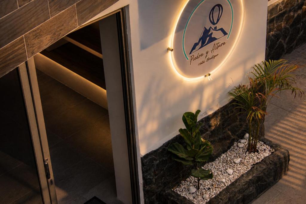 a lobby with plants and a sign on the wall at Hotel Boutique Piedra & Altura in San Juan Teotihuacán