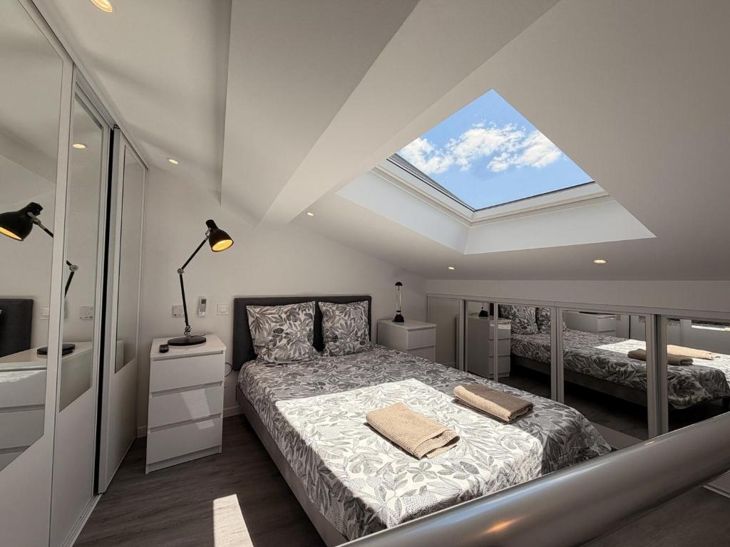 a bedroom with a bed and a skylight at *Climatisé* Duplex en hyper centre refait à neuf in Le Puy-en-Velay