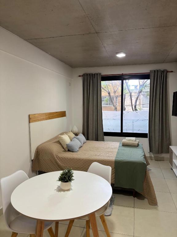 a bedroom with a bed and a white table at Bnb loft XlV - Pasos Bv oroño y Av pellegrini in Rosario