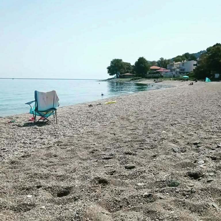 a chair sitting on a beach next to the water at Κατοικία στην Κουτσουπιά in Kokkino Nero
