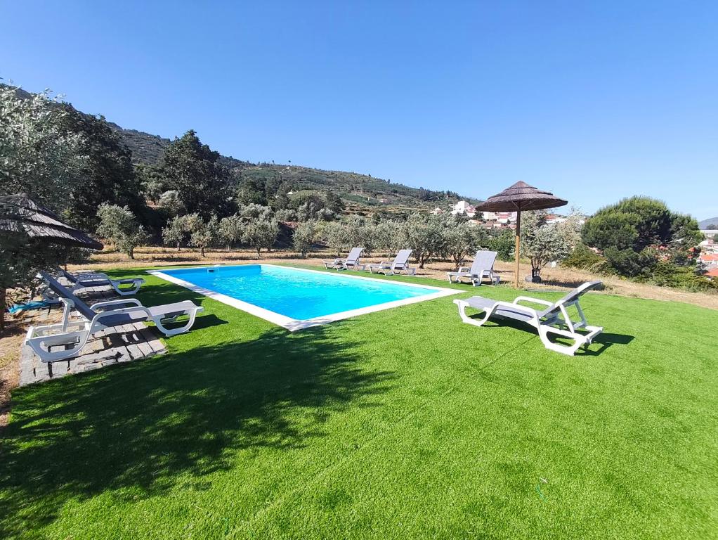 un cortile con piscina con sedie e ombrellone di Quinta de Gonçalo a Guarda