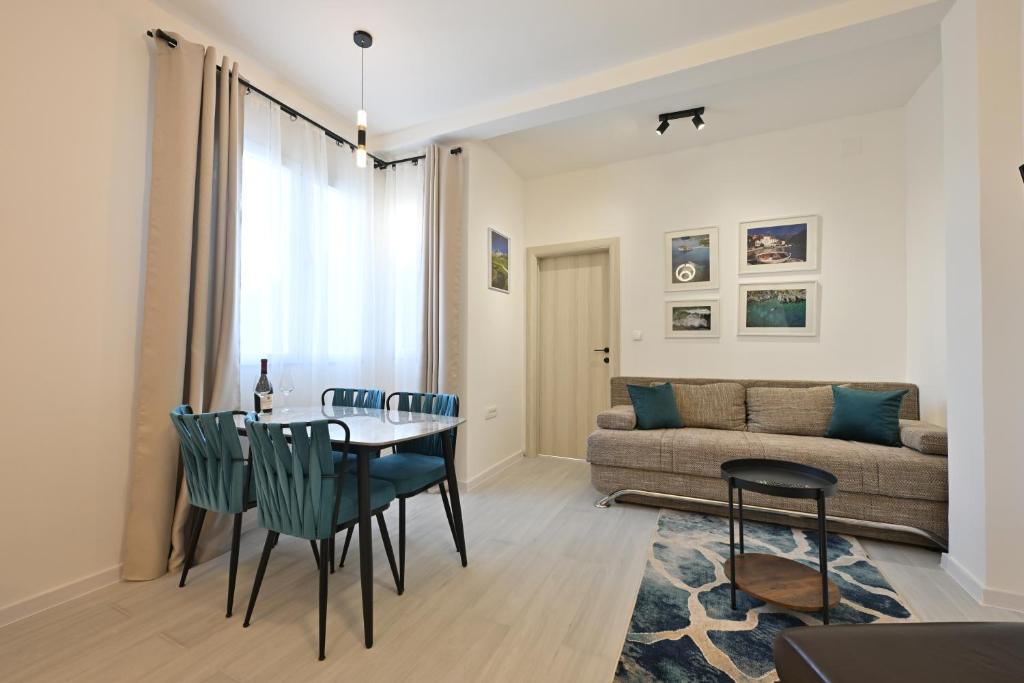 a living room with a table and chairs and a couch at Apartmani Oleander in Bar