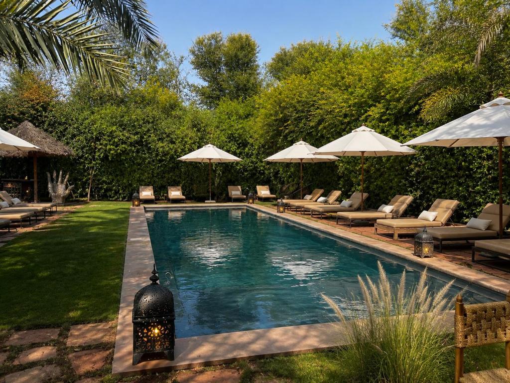 a swimming pool with chairs and umbrellas in a yard at La Ferme Berbere in Marrakesh