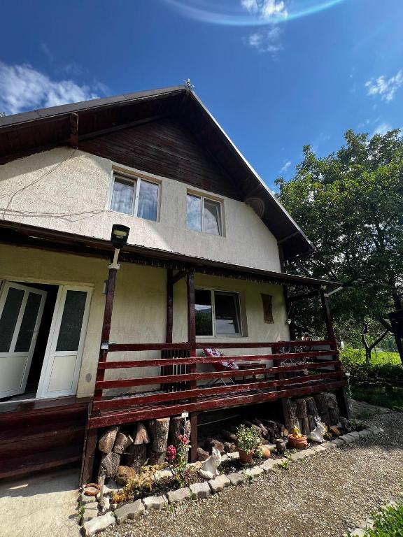 a house with a porch with a fence in front at Casa Dany in Zărneşti
