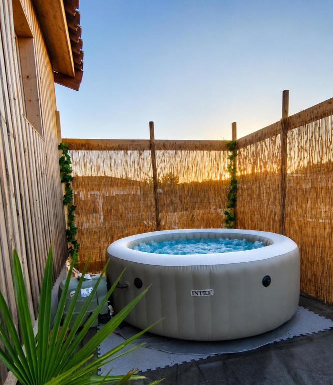 a bath tub sitting on the ground next to a fence at Le chalet d'Agathe in Largentière