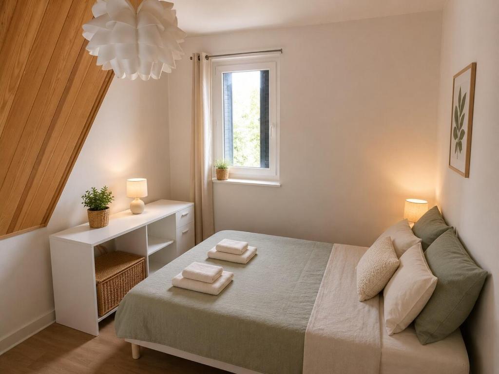 a bedroom with a bed with two towels on it at Maison Charton in Château-Chinon