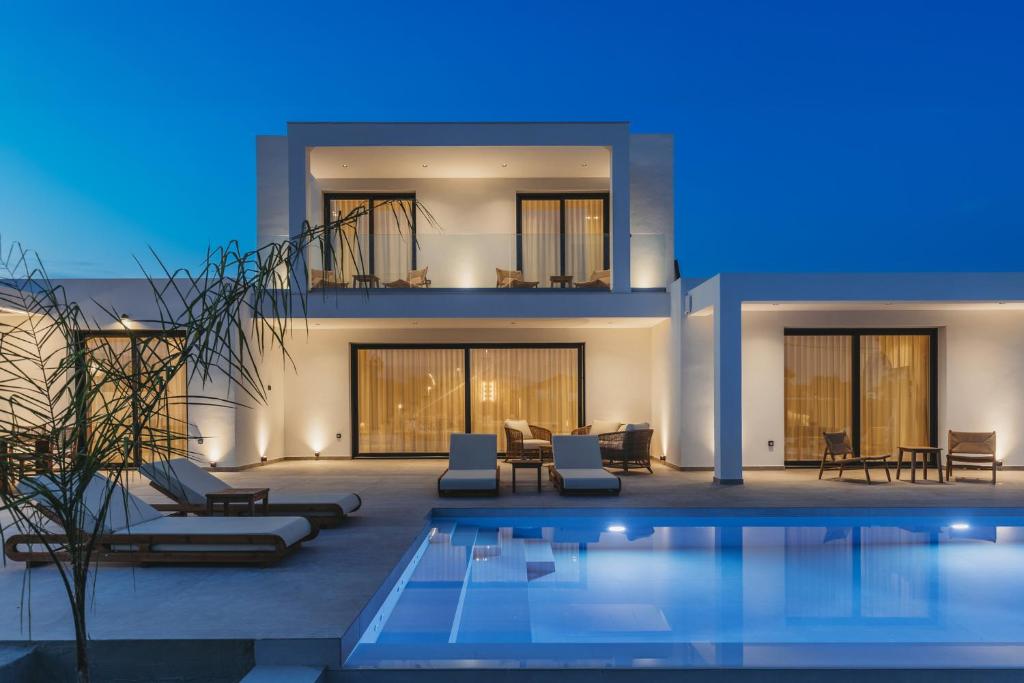 a villa with a swimming pool at night at Serenita luxury villa in Zakynthos