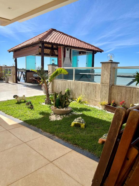 a house with a garden with turtles on the grass at Recanto Céu & Mar Casa de Praia em Manguinhos São Francisco de Itabapoana in São Francisco de Itabapoana