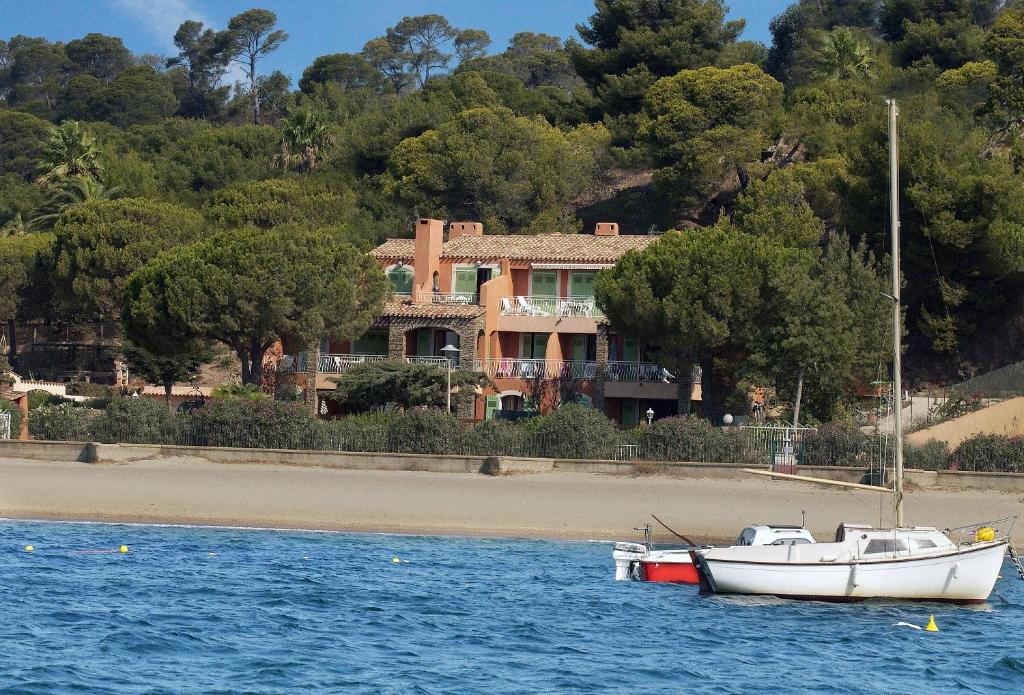 a boat in the water in front of a house at Villa L'ensoleillade in La Londe-les-Maures
