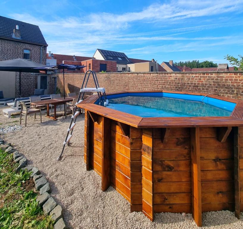 a swimming pool with a table and a ladder at Flandrien Hotel in Brakel