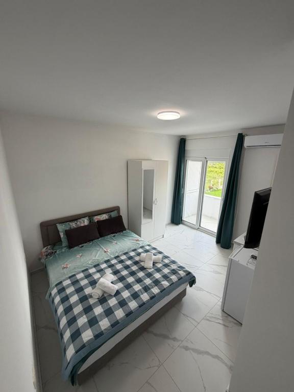 a bedroom with a bed with a checkered blanket on it at Apartments Gzim Peja in Ulcinj