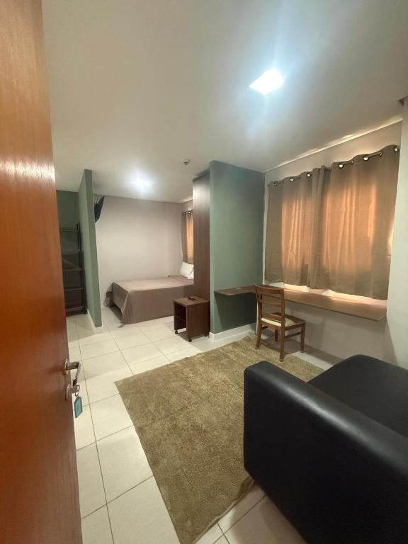 a living room with a bed and a couch at Residencial DOM in Lorena