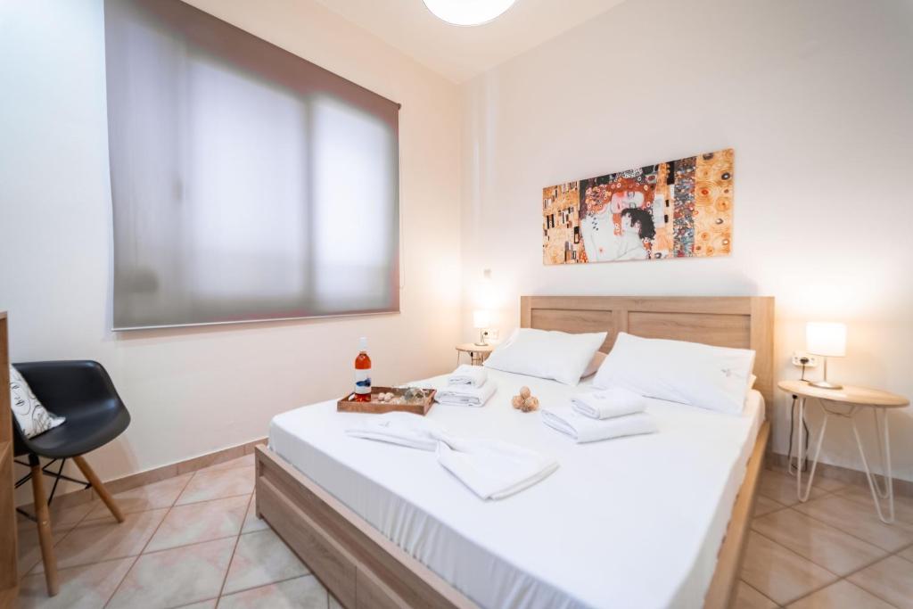 a bedroom with a bed with white sheets and a window at Rosso 3 City Centre Apartment in Heraklio