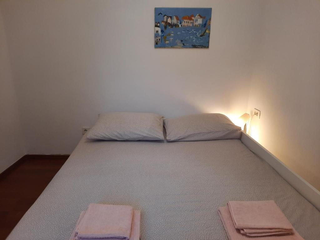 a bed in a room with two towels on it at Pipilota in Rijeka