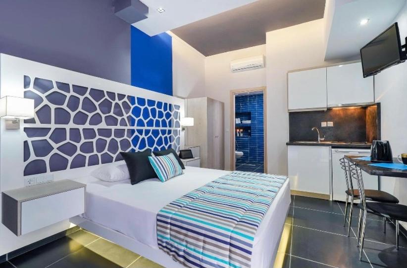 a bedroom with a large bed and a kitchen at Fresh Mare Apartments in Limenaria