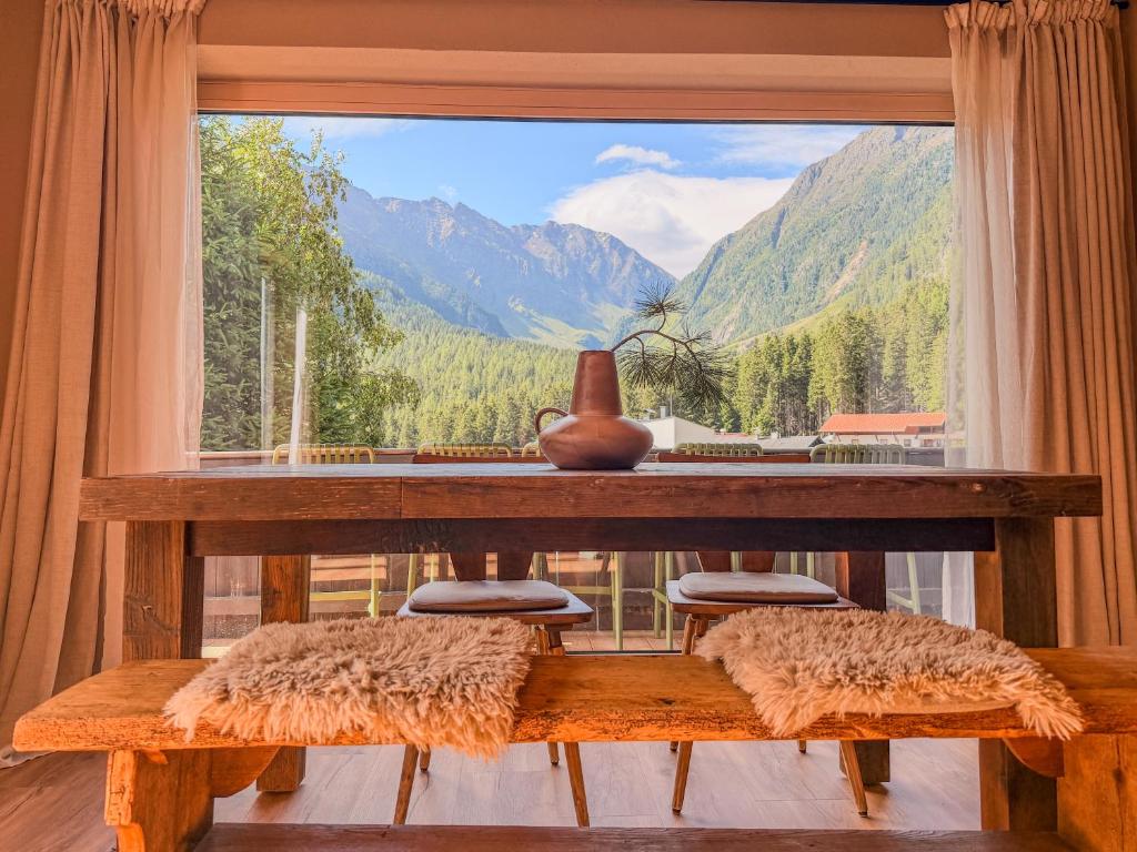 a room with a table and a large window at Alpine Apartments St-Sigmund in Sankt Sigmund im Sellrain
