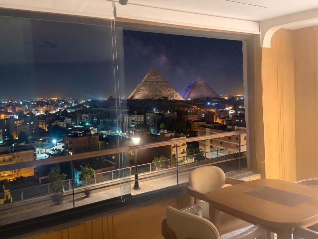 a room with a window with a view of the pyramids at Delta Pyramids Hotel in Giza