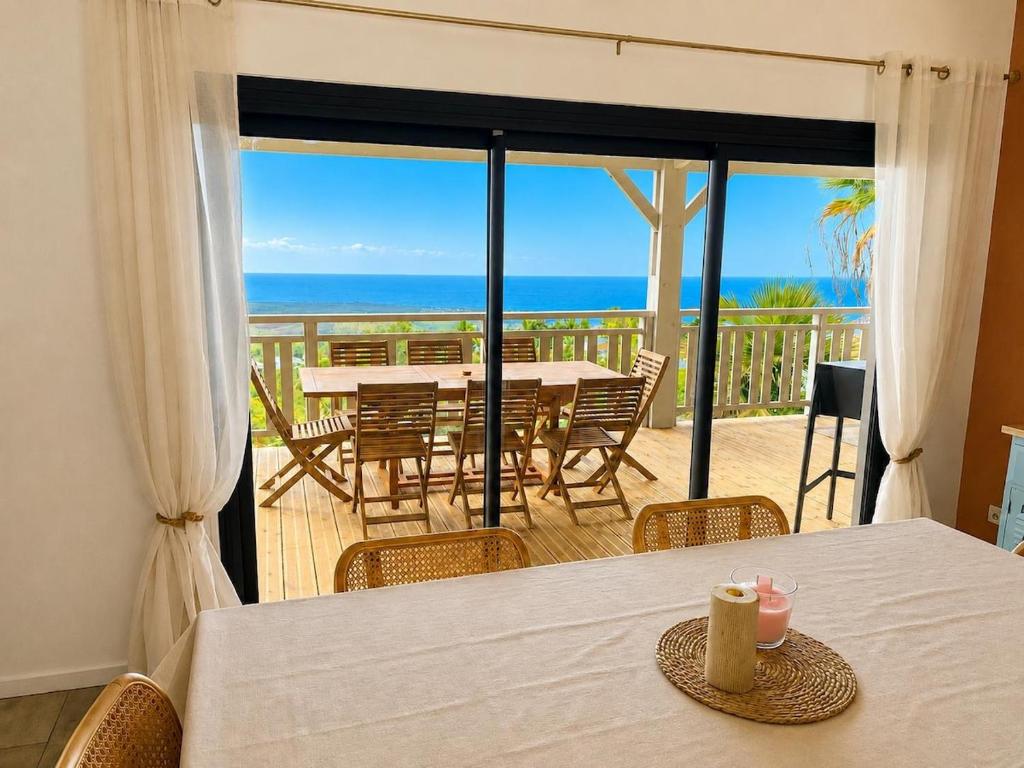 a dining room with a table and a view of the ocean at Kaz mer veille in Les Avirons